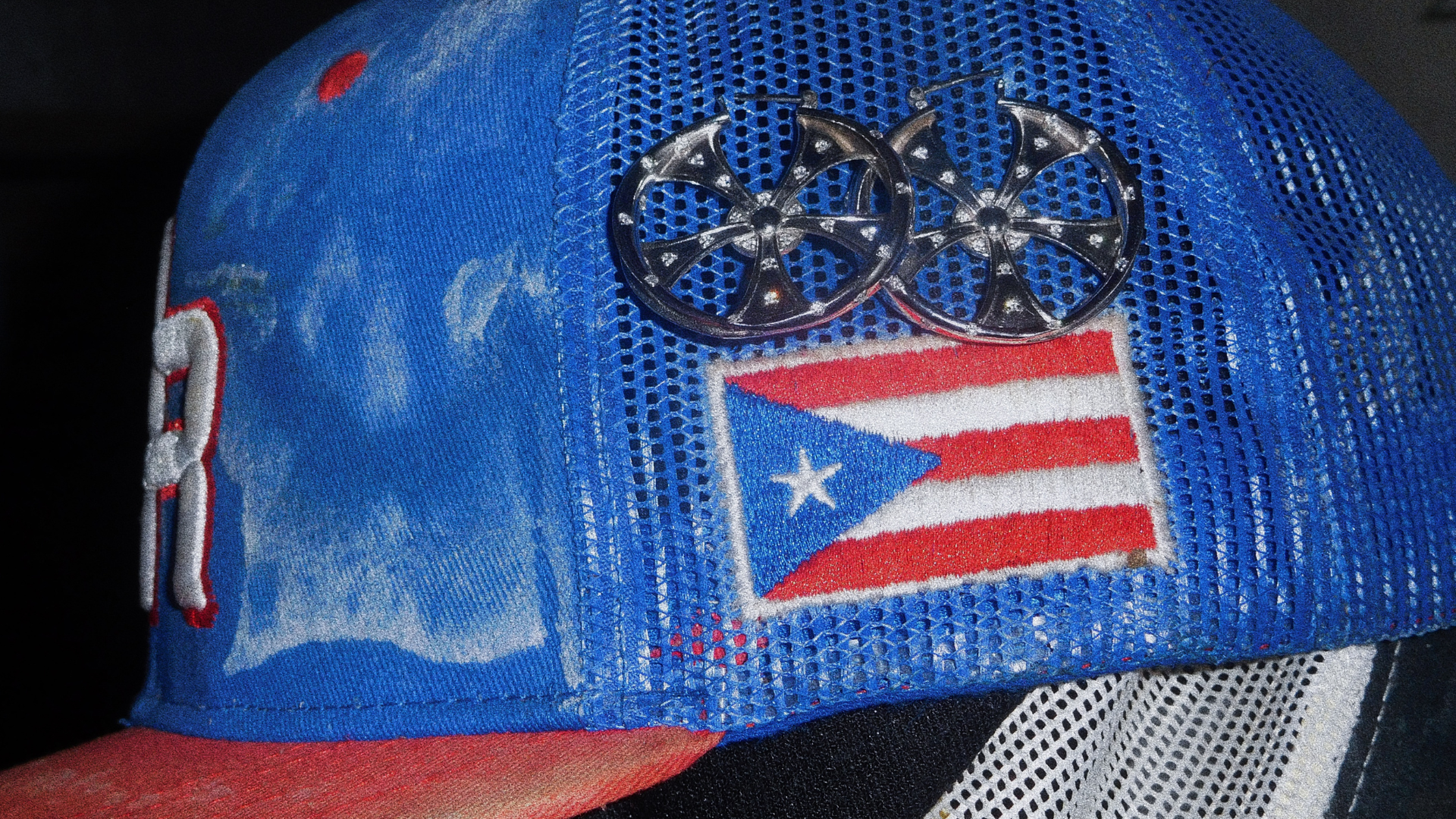 Blue cap with a Puerto Rican flag design and star emblem on a dark background